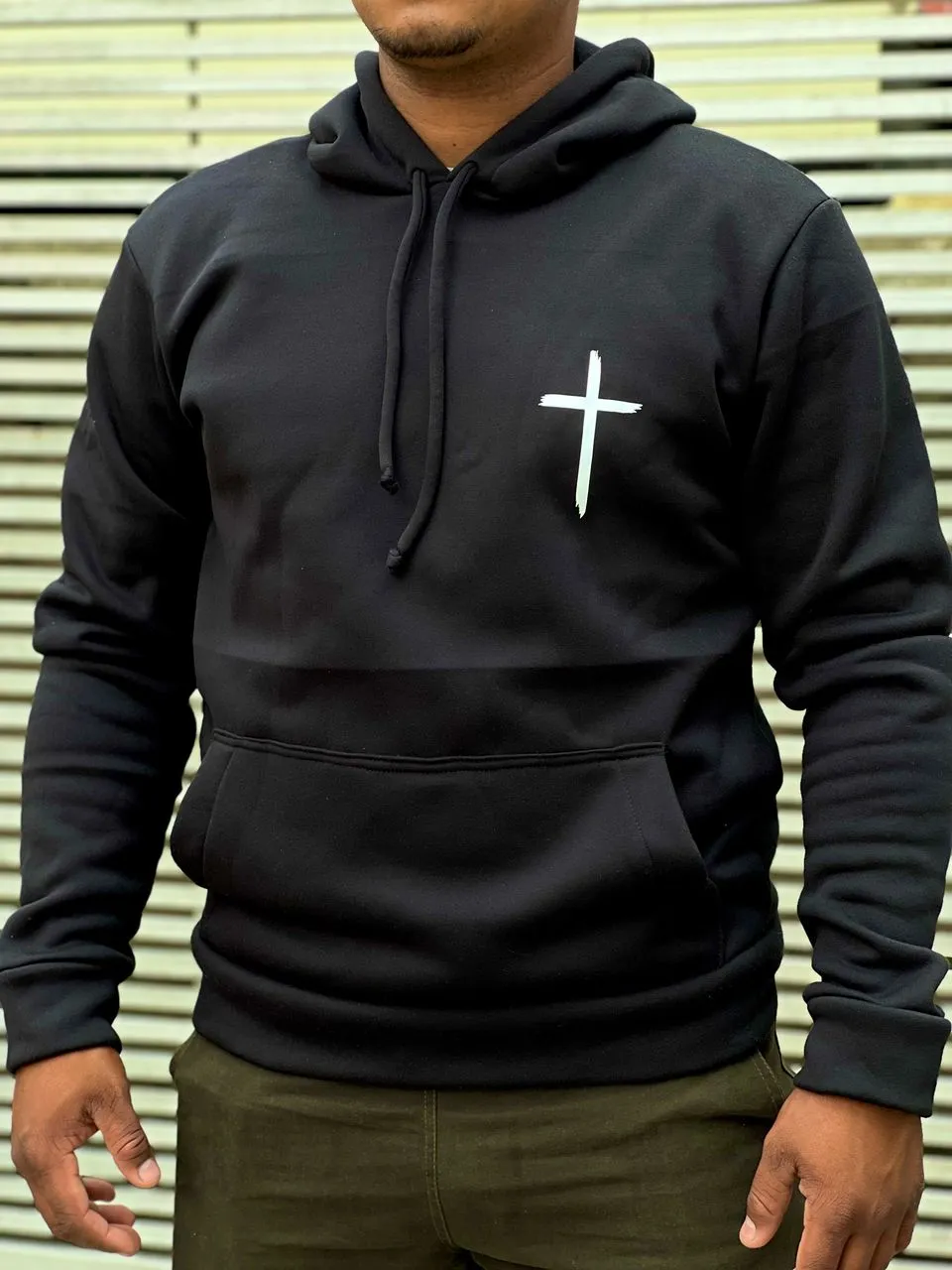 Suéter negro con una cruz blanca centrada en el pecho.